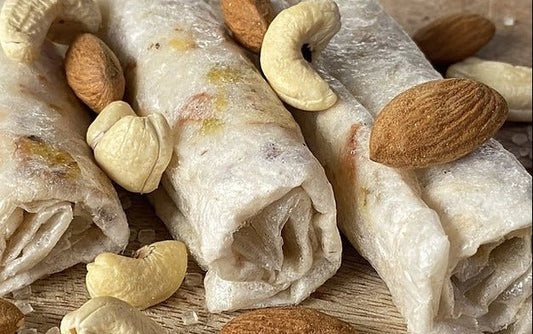 Close-up of Sugar Free Dry Fruit Cashew Almond Pistachio Papersweet rolls topped with almonds and cashews